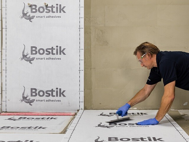 Man applying a waterproofing foil system to a floor