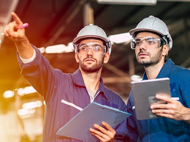 men in hard hats pointing at something