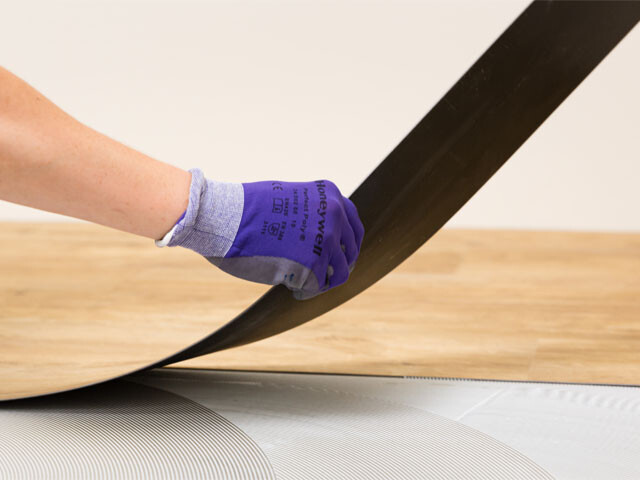 Flooring professional who installs a sheet of LVT