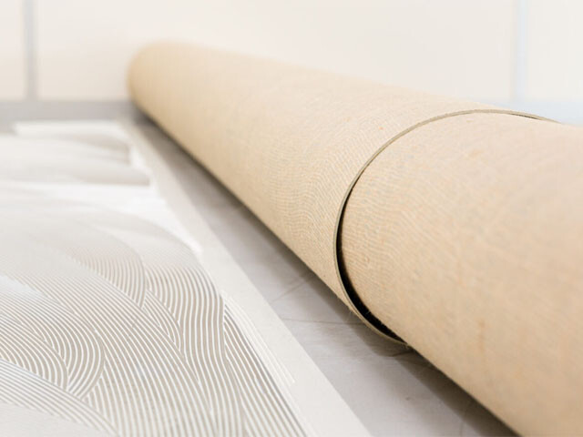 Rolls of linoleum ready to be installed over the adhesive