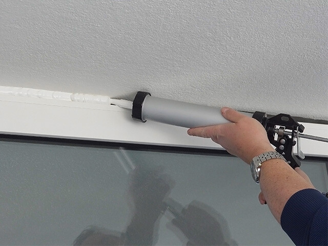 Sealant being applied to the outside of a home