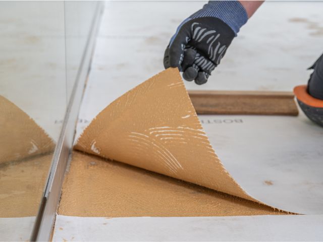 Lifting edge of Bostik decoupling underlay