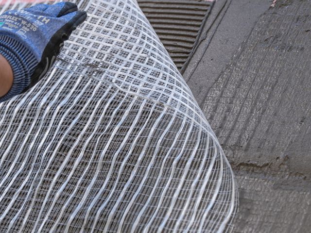 Embedding bridging mesh into floor adhesive