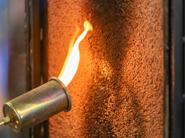 Close-up of a flame exposure test on a construction material surface, illustrating fire resistance evaluation for passive fire protection systems.