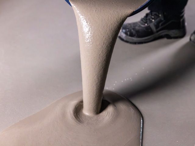 Pouring self-levelling compound onto a floor