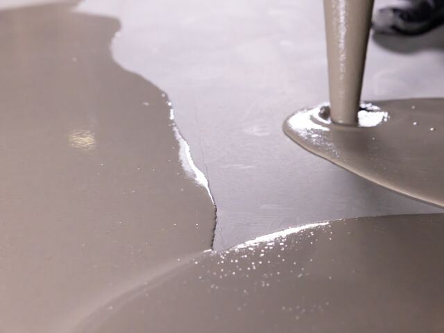 Pouring self-levelling compound over a floor crack