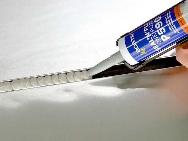 Bostik P390 sealant being applied in a straight joint on a smooth metal surface for flexible sealing.
