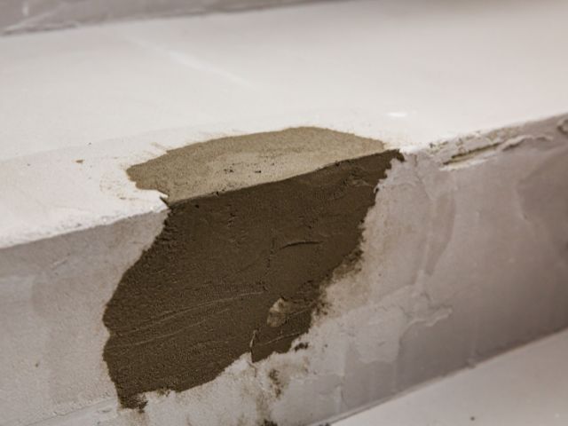 Repaired damaged edge of a concrete subfloor