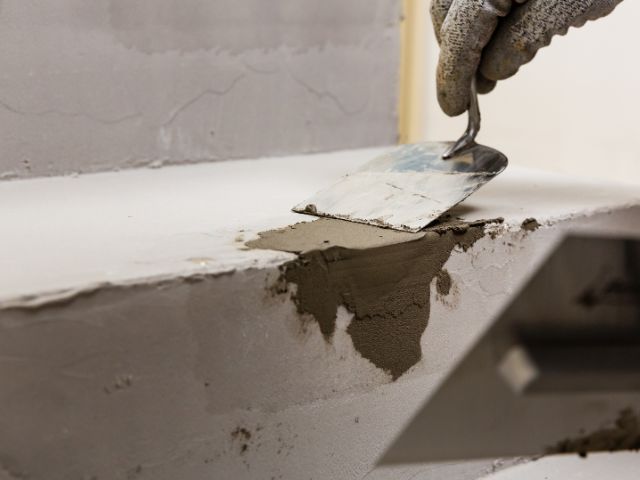 Smoothing repair mortar on a damaged concrete edge
