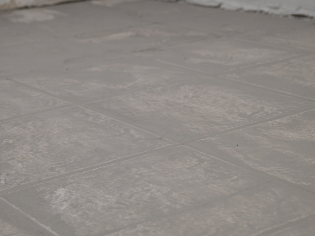 Prepared concrete floor surface with visible grid pattern, leveled and ready for installation using Bostik flooring solutions.
