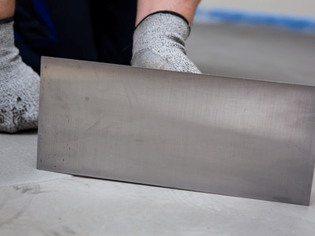 Close-up of a smoothing trowel positioned on a prepared concrete floor surface during Bostik floor levelling application.