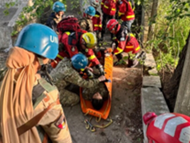 rescue workers in UN helmet active in woodland area