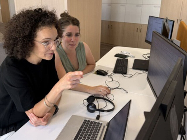 Kahina at work discussing with colleague
