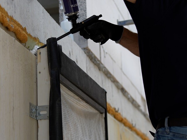 Applying tape to seal joints around the window frame