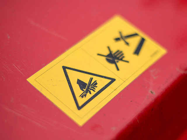 yellow safety stickers adhered to red panel
