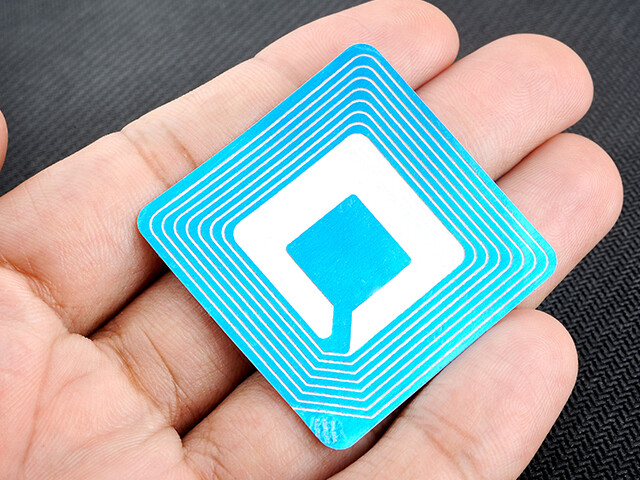 Blue and white RFID card held in the palm of a person's hand