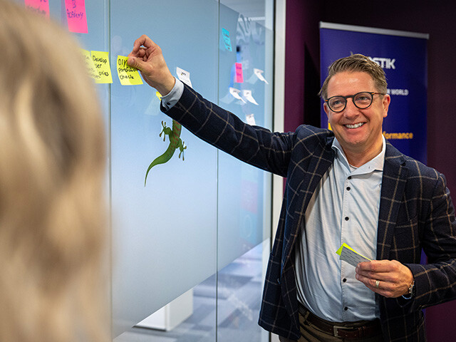 accountmanager sticking post its to a glass wall