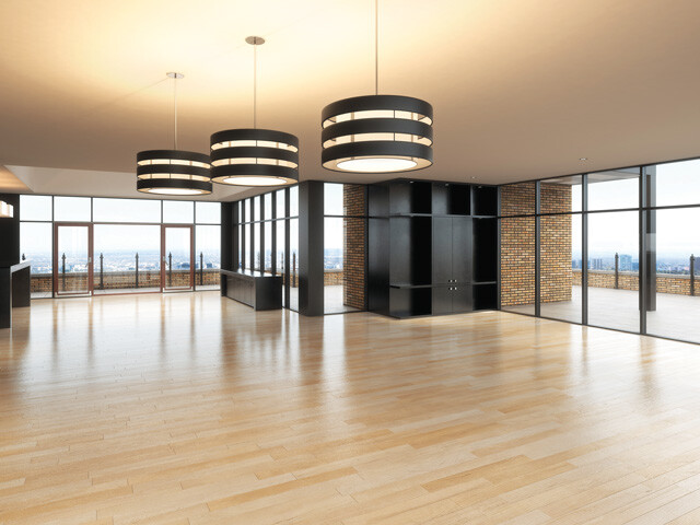 Light hardwood floors in a large, empty apartment space surrounded by windows.
