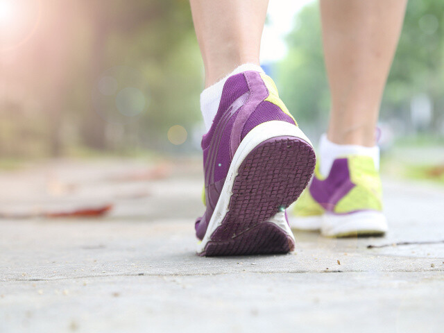 view of the underside of a shoe while a woman is walking