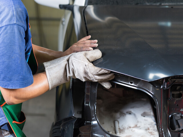 worker installing a bumper on an a car assembly line 