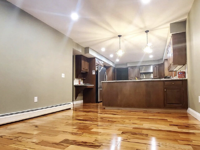 Remodeled kitchen area with hardwood flooring.