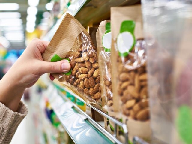 hand grabbing a bag of prepackaged nuts from a shelf